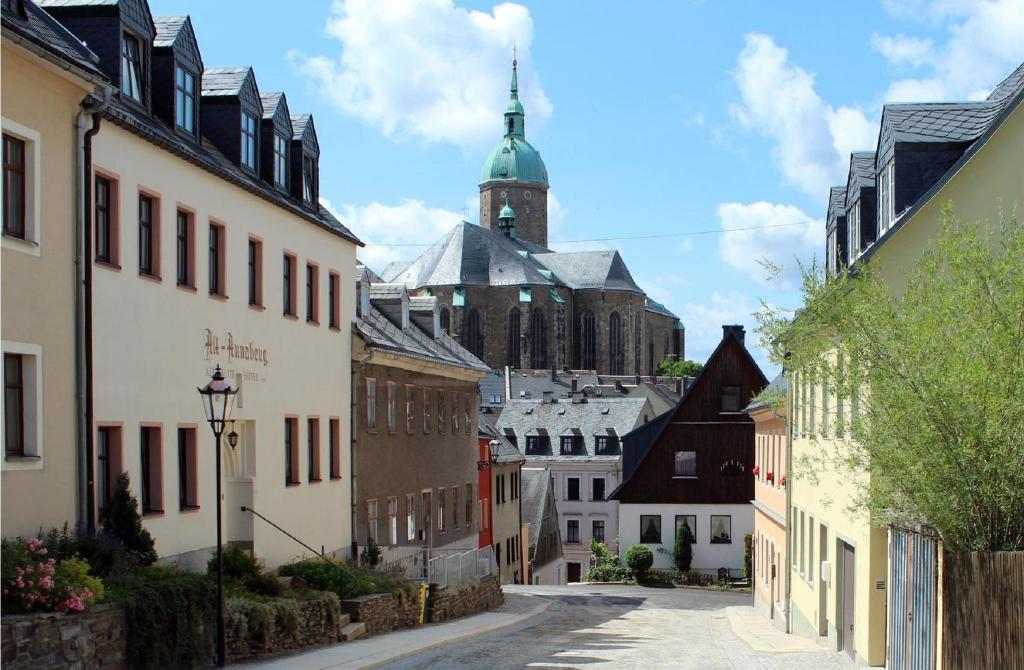 una calle de la ciudad con edificios y una iglesia en el fondo en Vierseitenhof Linke, en Annaberg-Buchholz