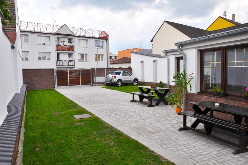 a patio with a table and benches in a yard at Penzion U Třeboňského kola in Třeboň