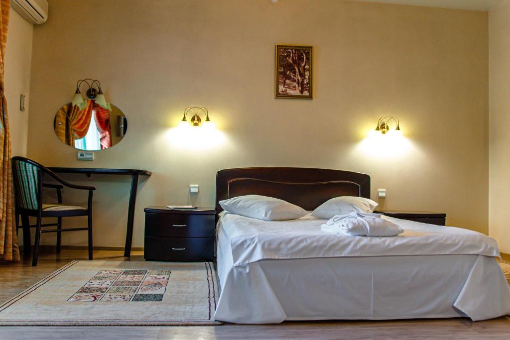 a bedroom with a bed with two pillows and a table at Boutique hotel Persona in Novokuznetsk