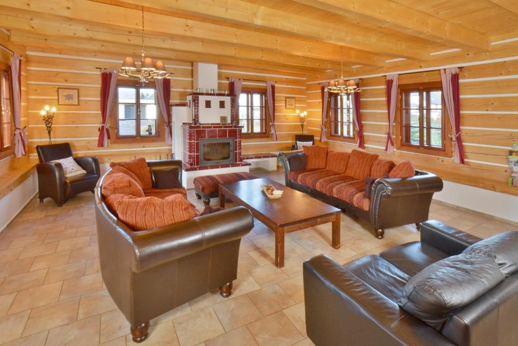 ein Wohnzimmer mit Ledermöbeln und einem Kamin in der Unterkunft Chalupa THEO se saunou a zahradní kuchyní in Vrchlabí