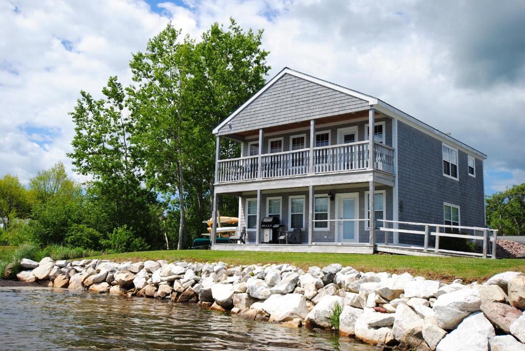 una casa sulla riva di uno specchio d'acqua di Keltic Quay Cottages & Bayfront Lodge a Whycocomagh