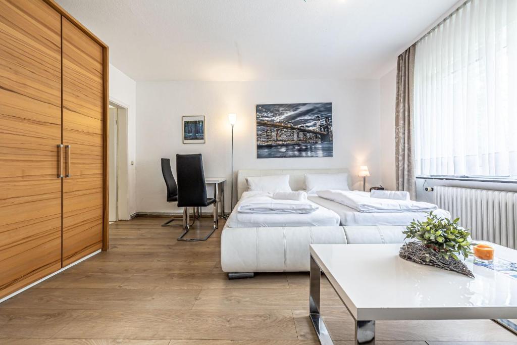 een hotelkamer met 2 bedden en een tafel bij Backskiste - Studioapartment im Erdgeschoss mit Gartenmitbenutzung in Flensburg