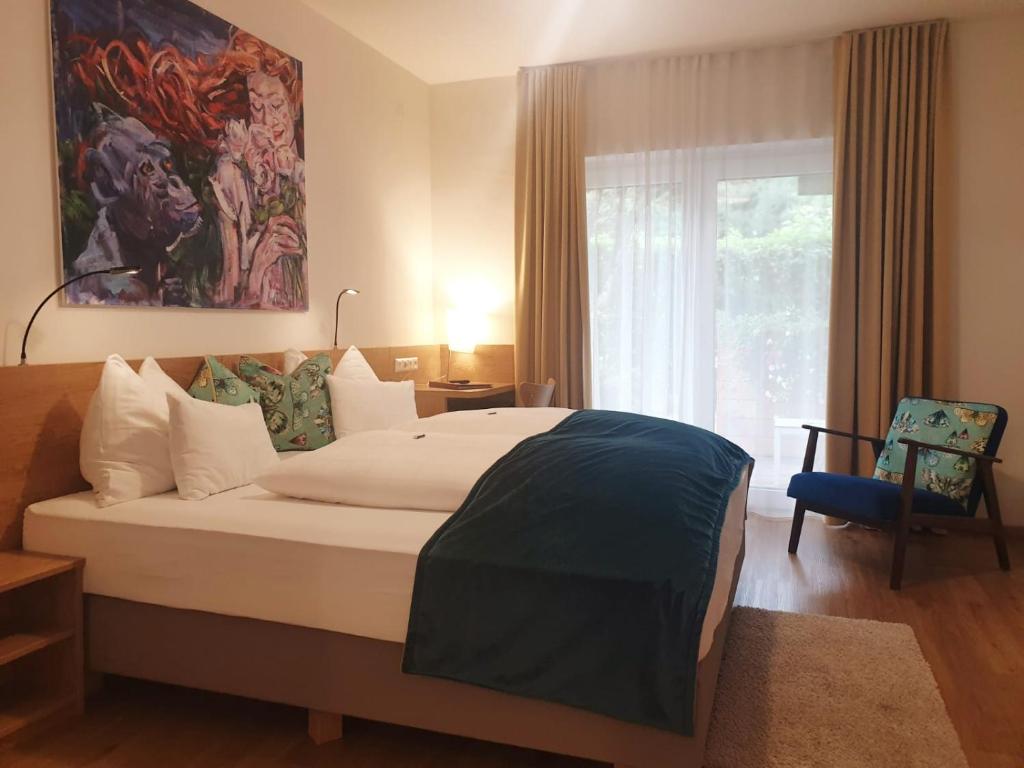 a bedroom with a large bed and a window at Hotel Garni Wurzer in Velden am Wörthersee
