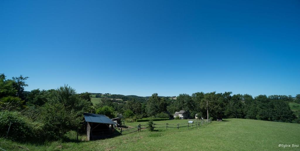 un campo con un granero y una valla en un campo en Chambre d'hotes La Source Aveyron, en Saint-André-de-Najac