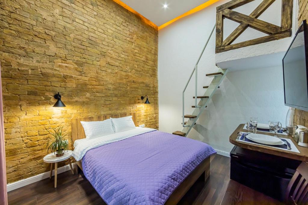 ein Schlafzimmer mit einem Bett, einem Waschbecken und einer Ziegelwand in der Unterkunft Kyiv Brown Loft in Kiew