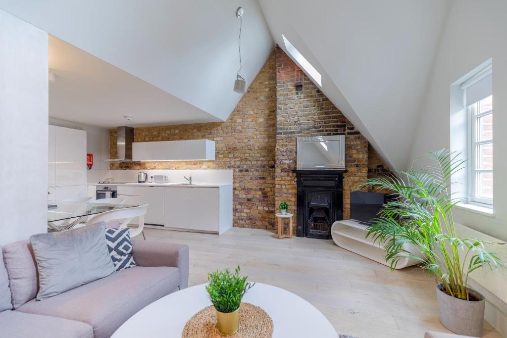 una sala de estar con un sofá y una mesa en Holborn by Excel Apartments, en Londres