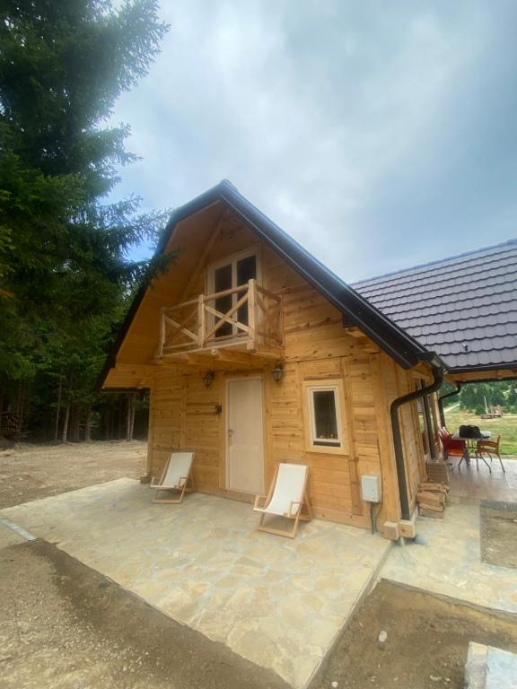 a log cabin with a porch and two chairs at Luxury Villa HORSE RIVER in Sekulić 