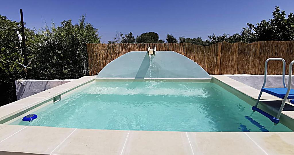 una piscina con scivolo in un cortile di terra rossa casa di campagna con piscina a Casarano