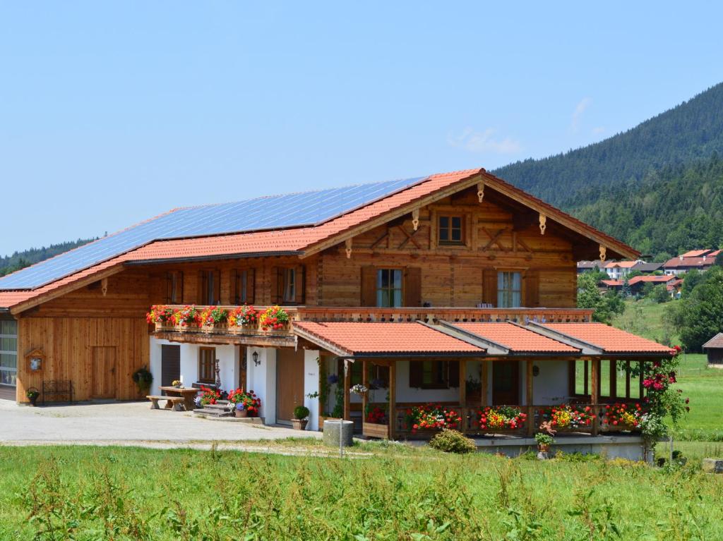 ein Holzhaus mit Sonnenkollektoren auf dem Dach in der Unterkunft Schusterbauer - Chiemgau Karte in Inzell