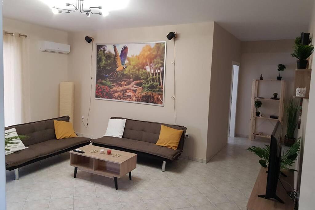 ein Wohnzimmer mit 2 Sofas und einem Couchtisch in der Unterkunft Chalkis Tropical House in Chalkida
