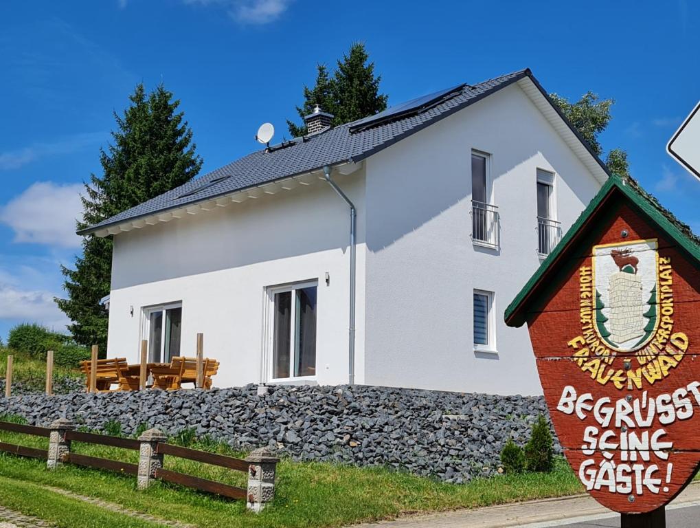 a white building with a sign in front of it at Ferienhaus Victoria in Frauenwald