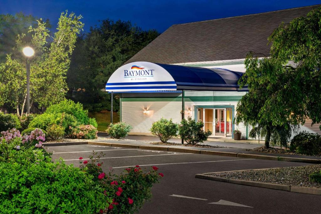 a building with an umbrella in a parking lot at Baymont by Wyndham North Dartmouth Fall River in North Dartmouth