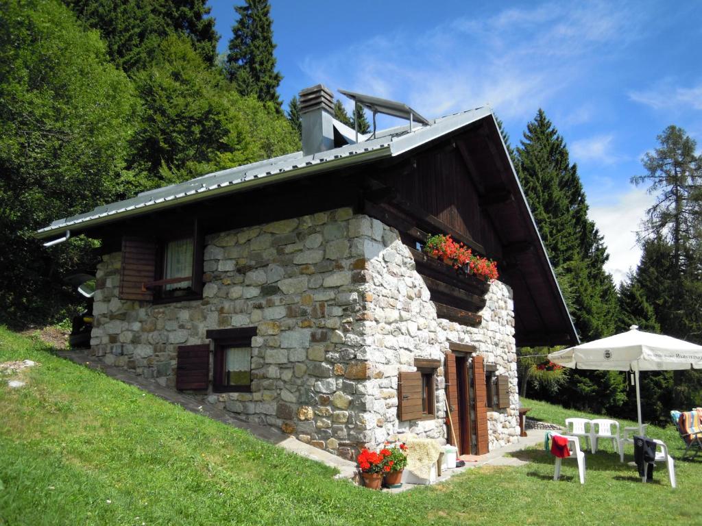a stone house with a roof on top of it at Baita Casa Pendola in Roncegno