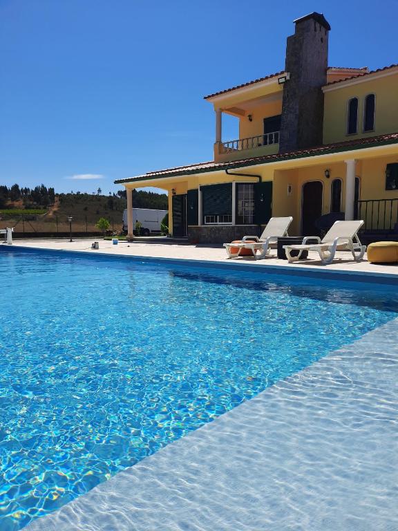 a villa with a swimming pool in front of a house at Eagle House in Sao Pedro de Tomar