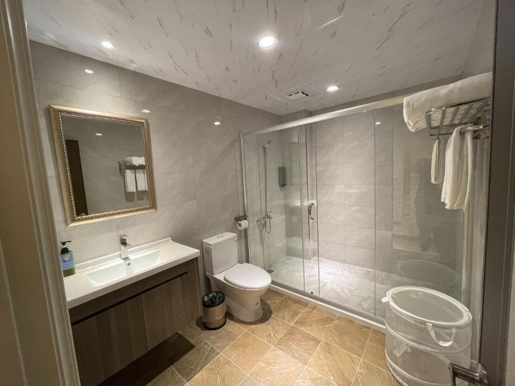 a bathroom with a shower and a toilet and a sink at 墾丁聚點旅棧 2Ps Hotel in Kenting