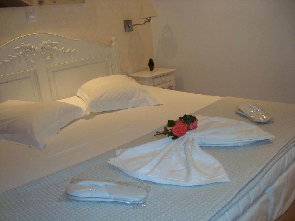 a white bed with a dress and a flower on it at Stampalia Luxury Studios in Astypalaia Town