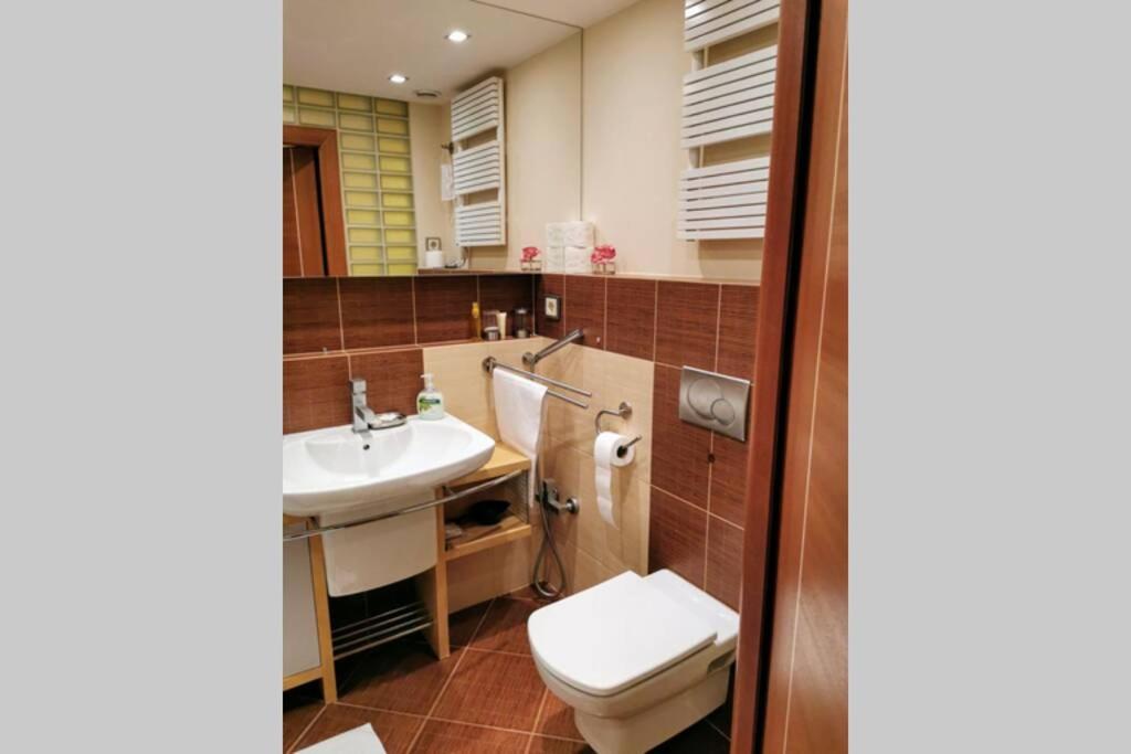 a bathroom with a toilet and a sink at Uroczy apartament przy deptaku z parkingiem. in Polanica-Zdrój