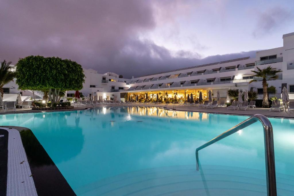 a large swimming pool in front of a hotel at Hotel Lanzarote Village in Puerto del Carmen