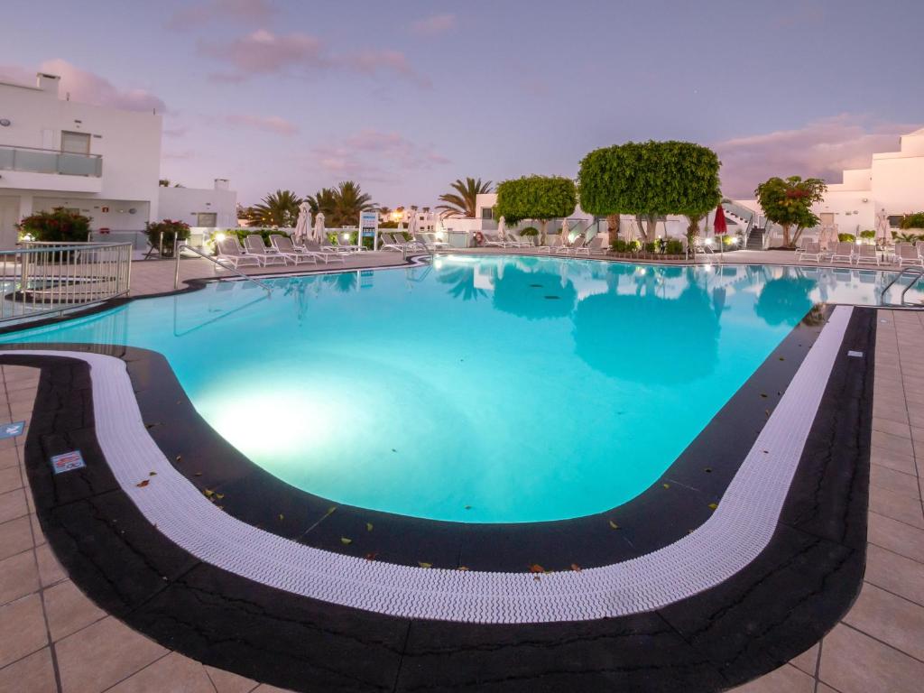 a large swimming pool with blue water at Hotel Lanzarote Village in Puerto del Carmen