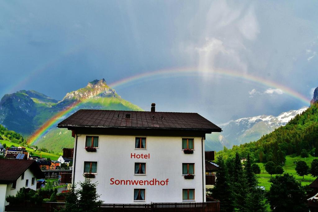 a rainbow over a building with a hotel at Hotel Sonnwendhof Engelberg in Engelberg
