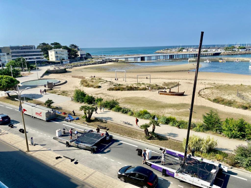 a view of a beach and a street with cars at Superbe studio face mer in Pornichet