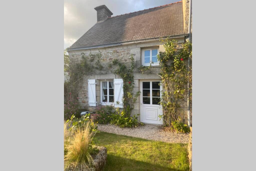 una casa con una puerta blanca y un patio en Le Penty Yvi, en Saint-Avé