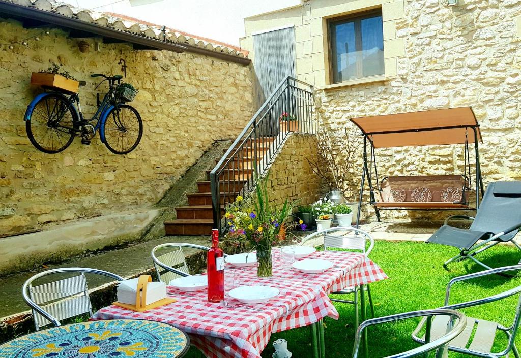 einen Tisch und Stühle mit einem an einem Gebäude hängenden Fahrrad in der Unterkunft Casa Rural Basaula in Muneta