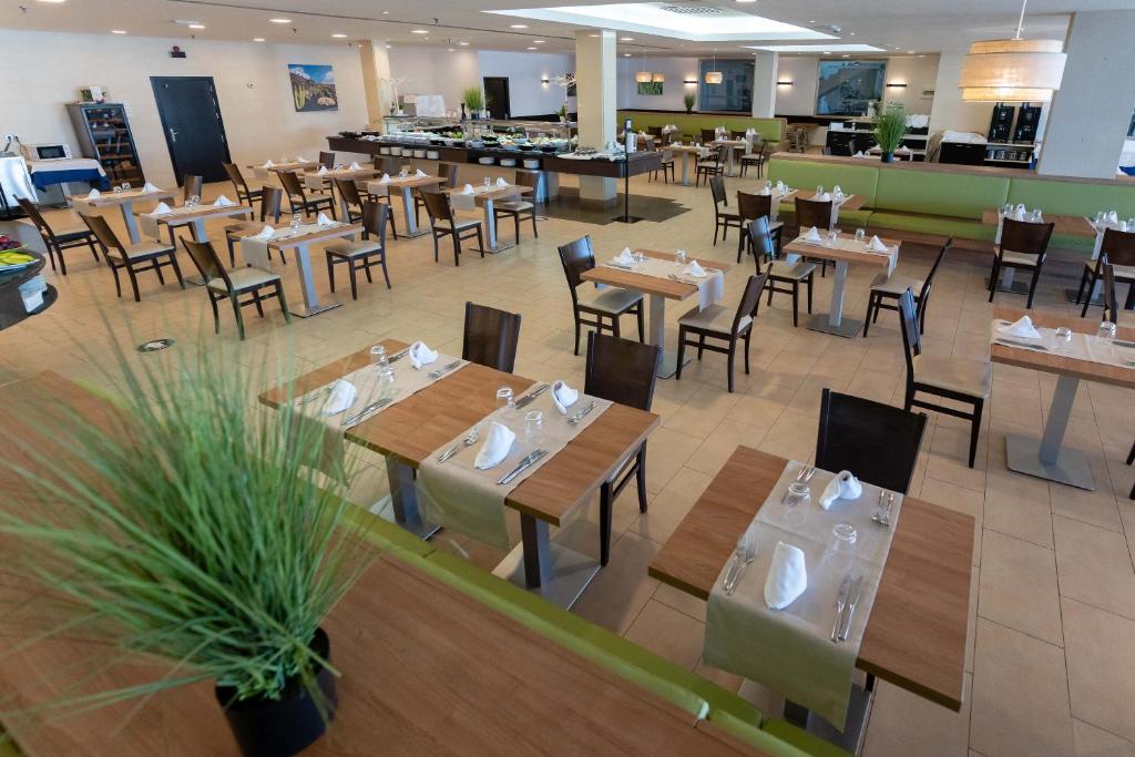 a restaurant with wooden tables and chairs and a cafeteria at Hotel Lanzarote Village in Puerto del Carmen