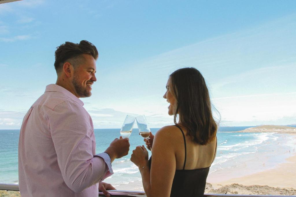 a man and a woman holding white wine glasses at Esplanade Hotel in Newquay