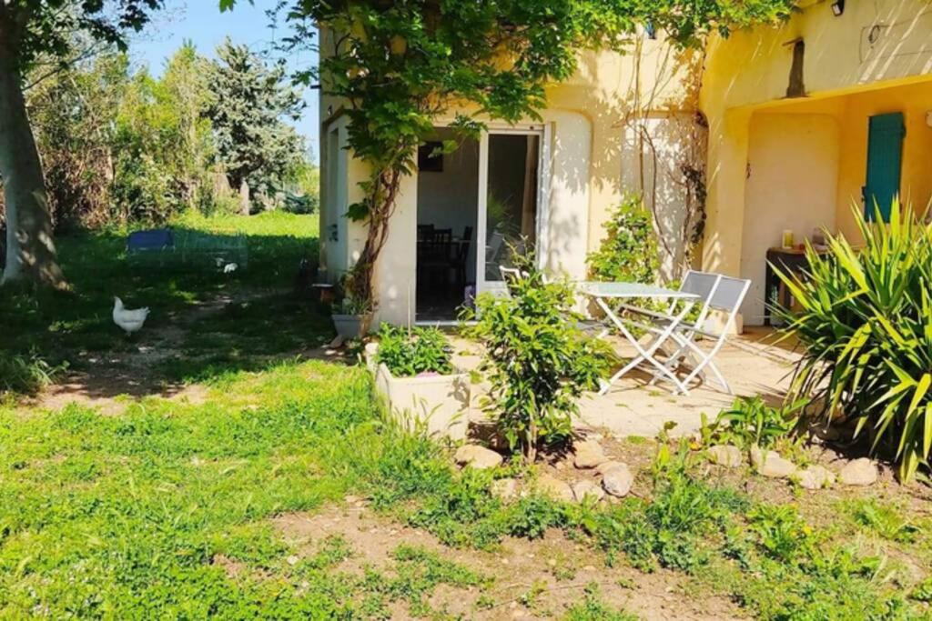 une maison avec une table et une chaise dans la cour dans l'établissement Offrez-vous un séjour dans notre gîte à Entressen Une grande piscine pour se rafraîchir ,un espace de jeux pour enfants pour des heures de divertissement Un terrain de pétanque pour des parties endiablées, à Entressen