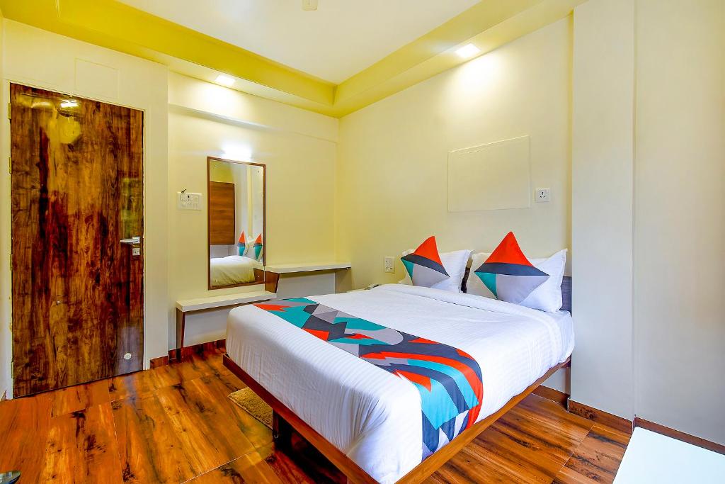 a bedroom with a large white bed in a room at FabHotel Nandanvan in Pune