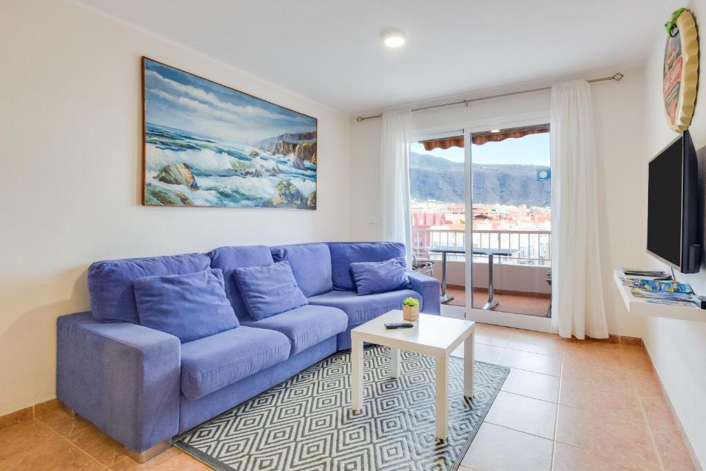 a blue couch in a living room with a window at Apartamento Deluxe in Candelaria