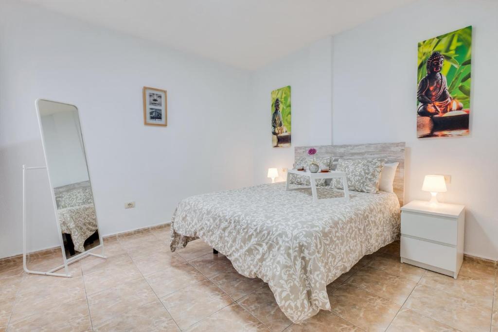 een witte slaapkamer met een bed en een spiegel bij Three bedroom apartment ii near Sc in Bocacangrejo
