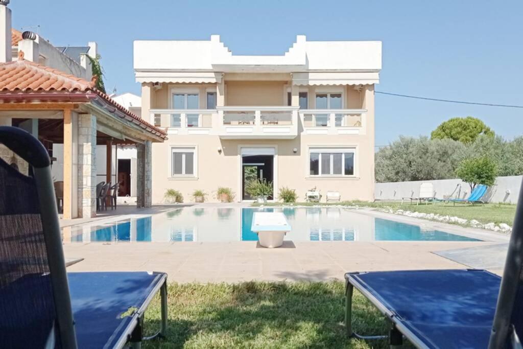 a villa with a swimming pool and a house at Villa IRENE Evia, 4 bdr, Pool, 500m to Beach in Magoúla