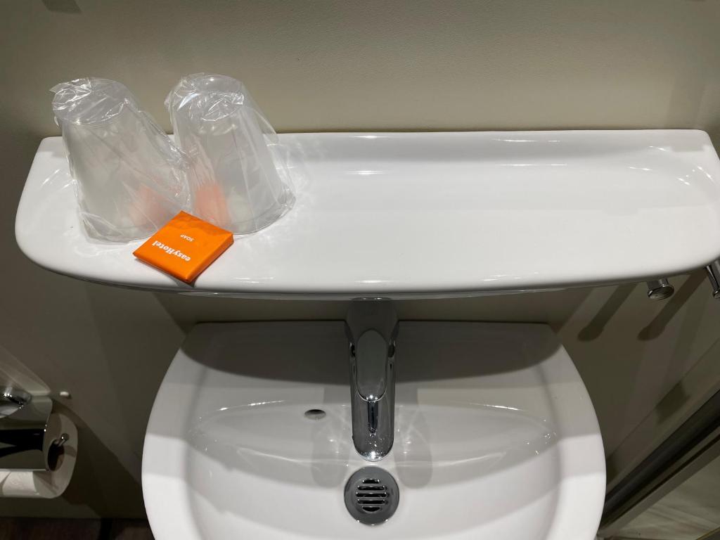 ein weißes WC mit einem Waschbecken darüber in der Unterkunft easyHotel Zürich Limmatplatz in Zürich