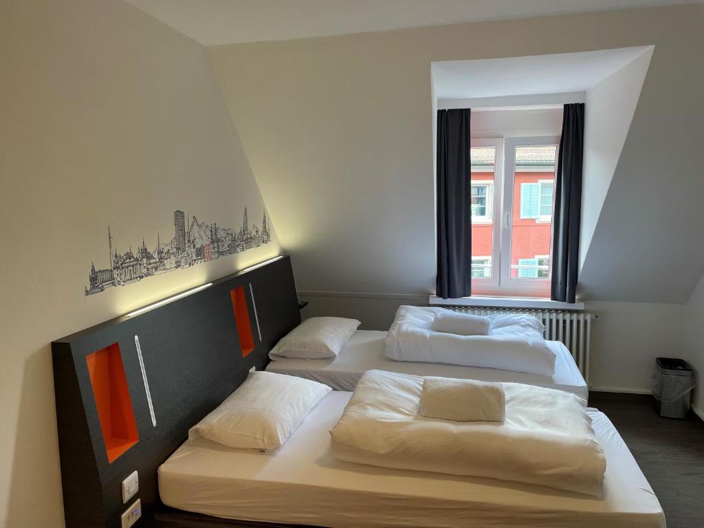 drei Betten in einem Zimmer mit Fenster in der Unterkunft easyHotel Zürich Limmatplatz in Zürich
