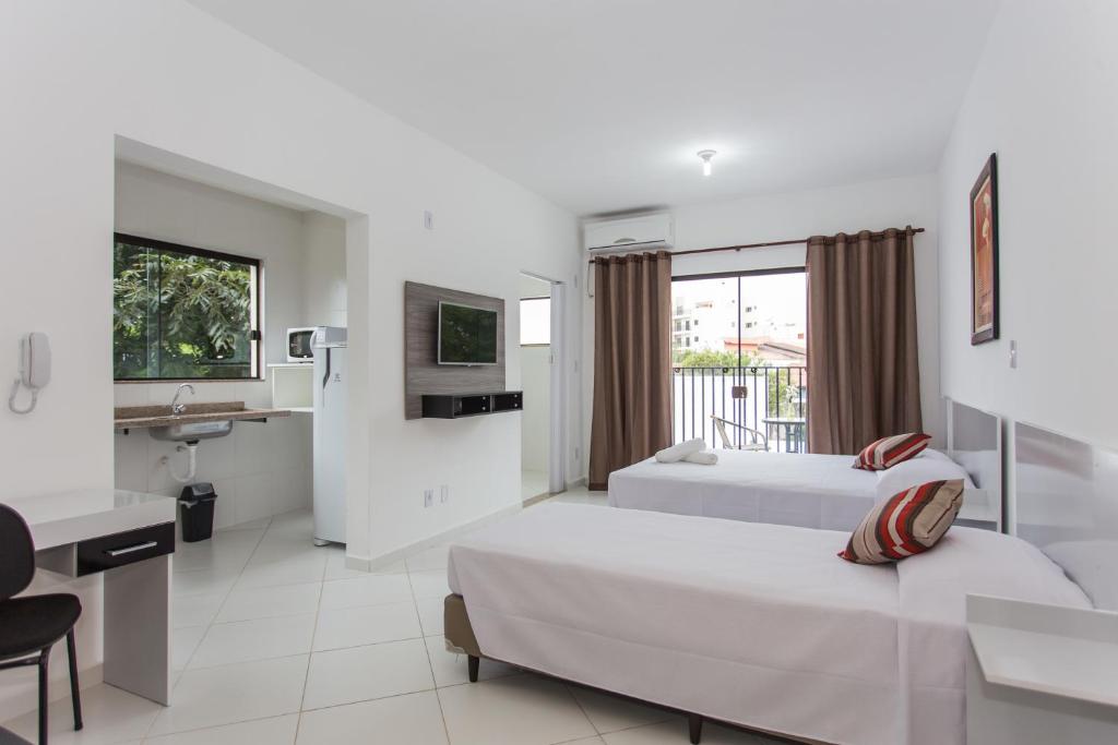 a hotel room with two beds and a bathroom at Domum Hotel in Pindamonhangaba