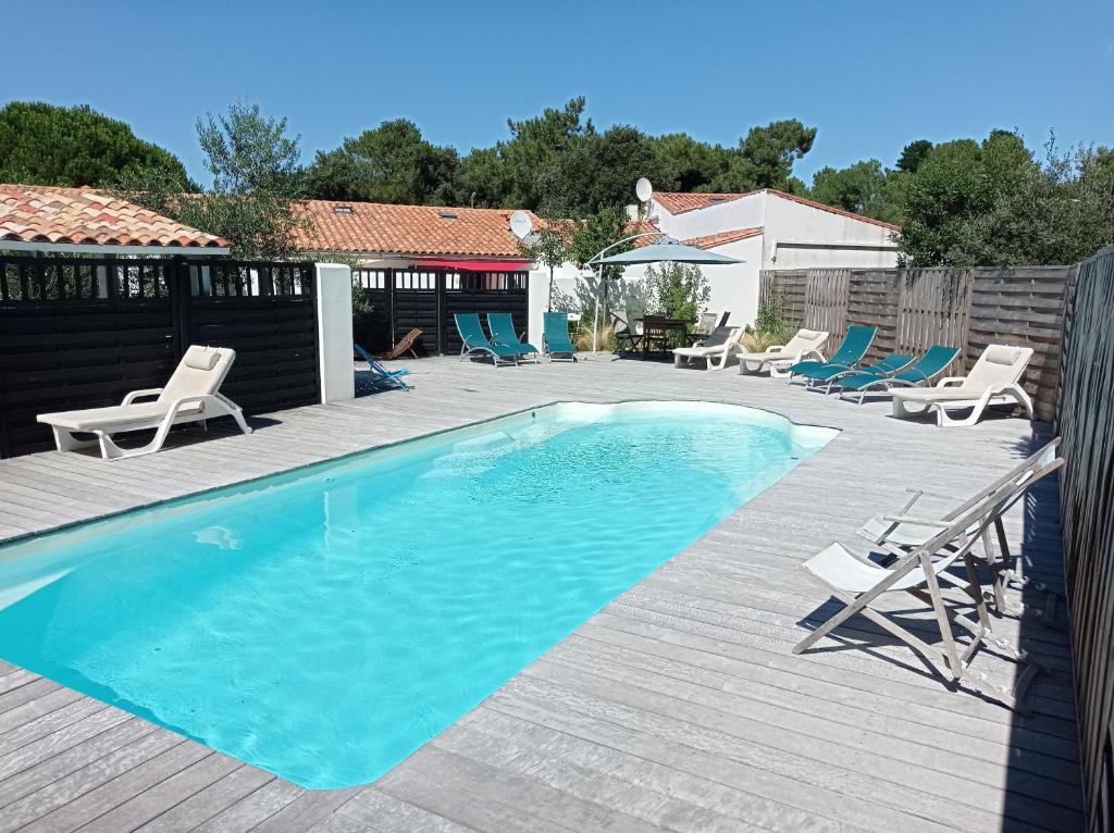 uma piscina com espreguiçadeiras e uma piscina em Le Clos des Pins em Rivedoux-Plage