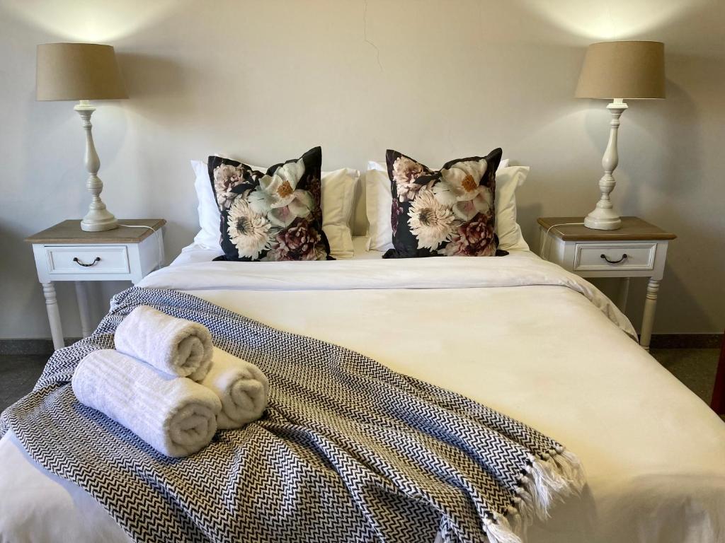 a bedroom with a bed with towels on it at Tidor Garden Cottage in Bloemfontein