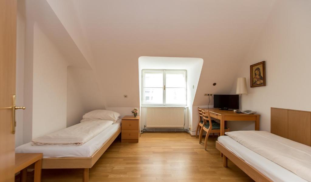Un pat sau paturi într-o cameră la Gästehaus Deutscher Orden Wien