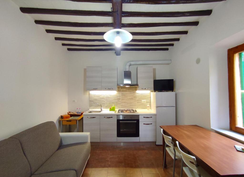 a kitchen with a couch and a table in a room at Casa via della Rocca Luna in Poggibonsi