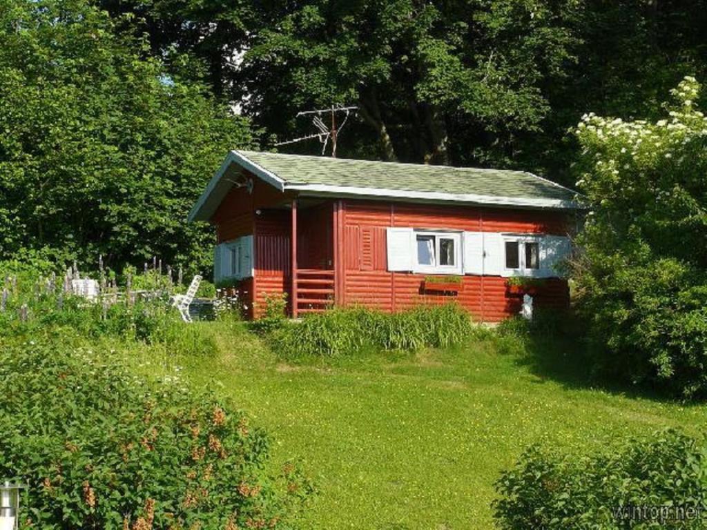 une petite maison rouge dans un champ d'herbe dans l'établissement Ferienhaus Keller, à Freyung