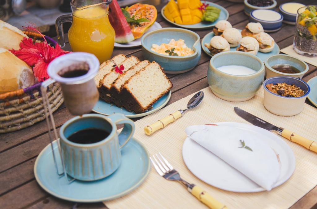 a table with breakfast foods and a cup of coffee at Pousada Cocar Caraíva in Caraíva