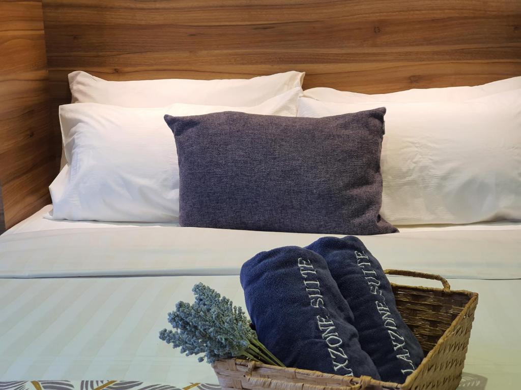 a bed with white pillows and a basket on it at Aeropod Studio - Laxzone in Kota Kinabalu