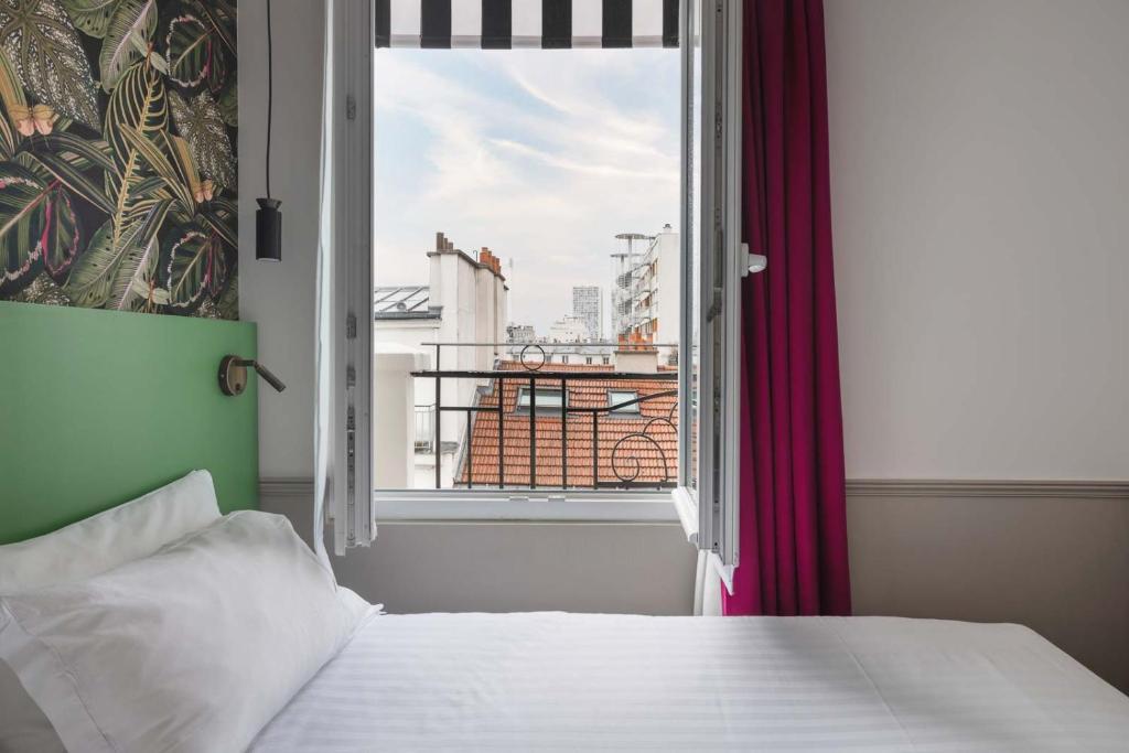 a bedroom with a bed and a window with a view at Hôtel 31 - Paris Tour Eiffel in Paris