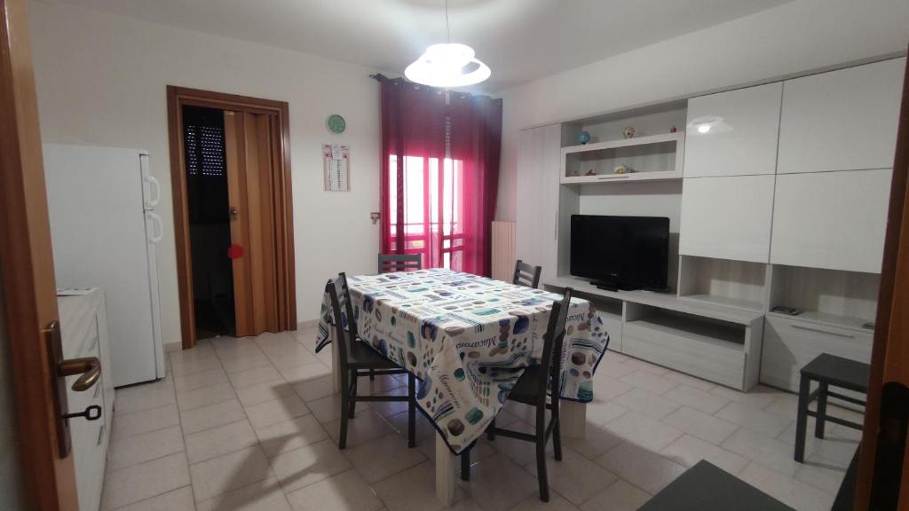 comedor con mesa, sillas y TV en Casa di Gigi- comodo appartamento in Galatina, en Galatina
