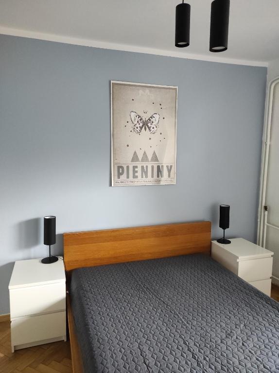 1 dormitorio con 1 cama y una foto de una mariposa en Apartament Pod Taborem, en Niedzica Zamek