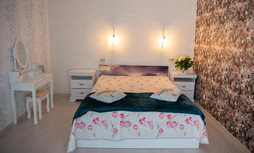 um pequeno quarto com uma cama e duas mesas de cabeceira em Nameja Apartments em Jēkabpils