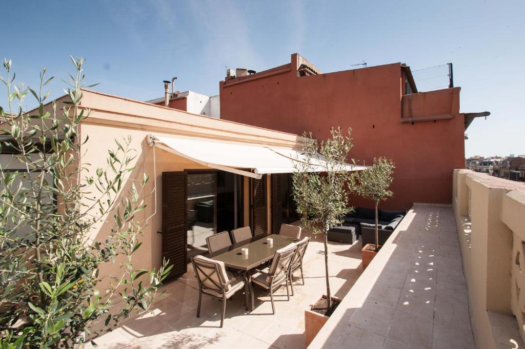 een patio met een tafel en stoelen op een dak bij BCN Apartments 41 in Barcelona