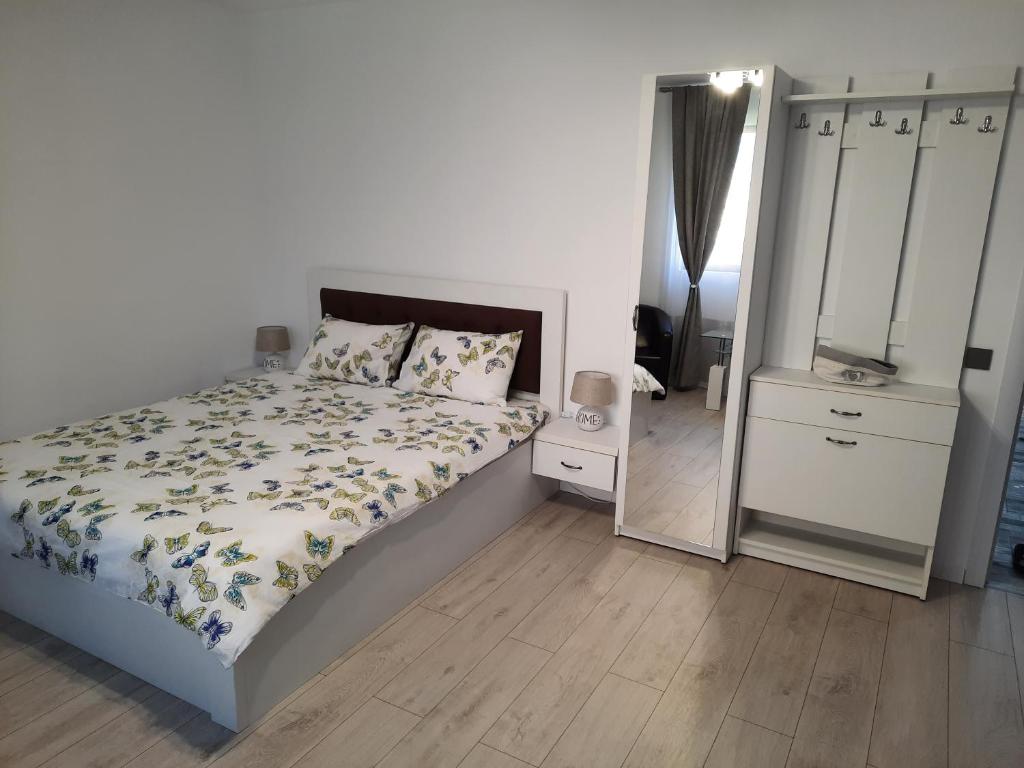 a white bedroom with a bed and a mirror at CASA GIA CALIMANESTI in Călimăneşti